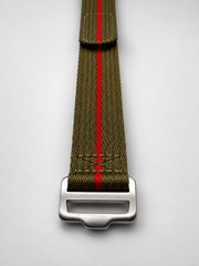 An olive green webbed watch strap with a single vibrant red center stripe and a brushed steel heavy duty buckle